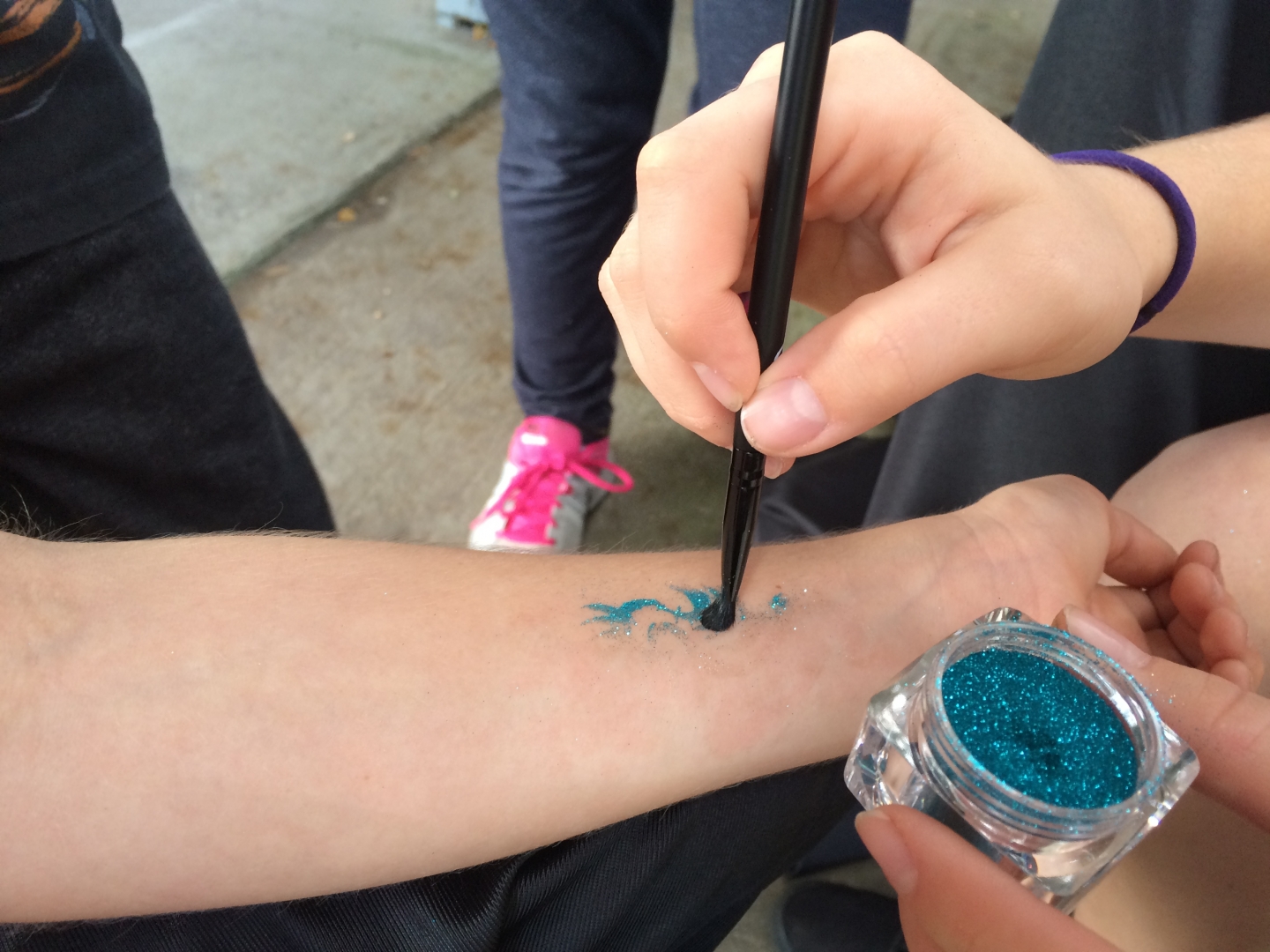 Blue Glitter Tattoo being carefully applied